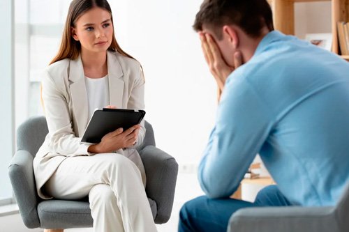 Пациент на консультации Мужчина сидит опустив лицо в руки